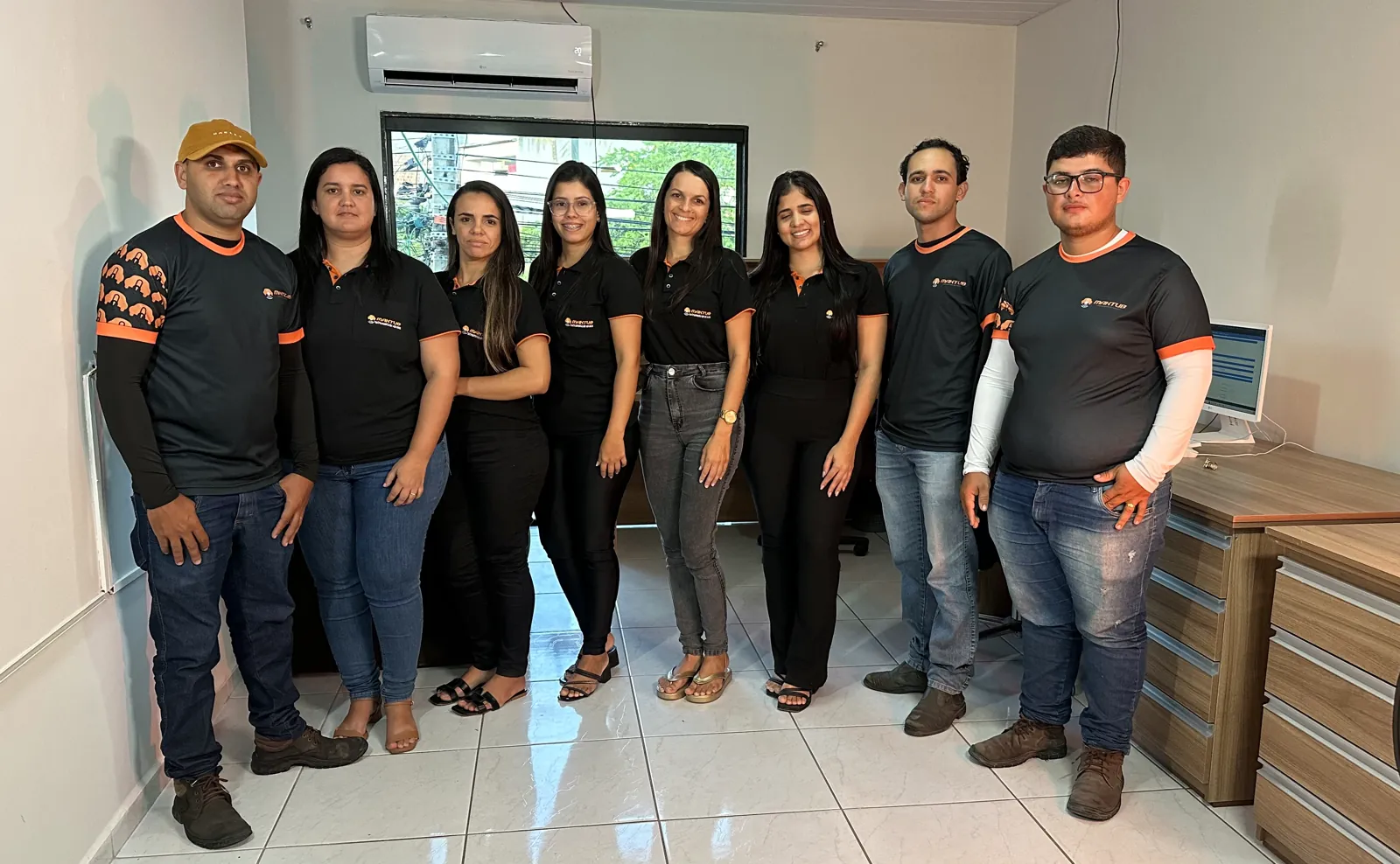 Equipe da Maktub Rastreamento reunida no escritório, com uniformes da empresa